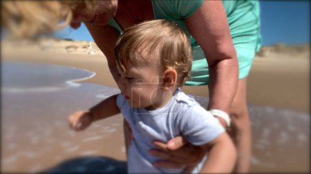 Photo for Toddler at beach shore for first time. Baby infant feeling water - Royalty Free Image
