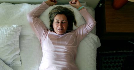 Téléchargez les photos : Happy person lying down in bed resting and relaxing - en image libre de droit