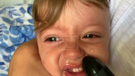 Téléchargez les photos : Parent enlevant le mucus du bébé avec de l'eau salée - en image libre de droit