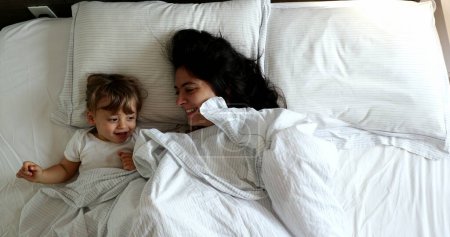 Téléchargez les photos : Mother and baby toddler in bed, morning top view perspective - en image libre de droit