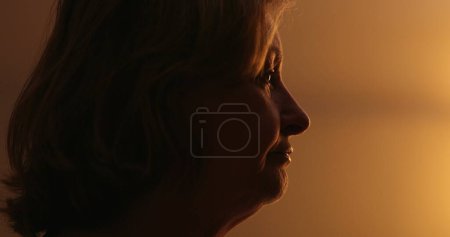 Photo for Anxious older woman suffering at night, close-up face. Troubled person rubbing face with hand - Royalty Free Image