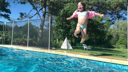 Téléchargez les photos : Petite fille sautant dans l'eau de la piscine - en image libre de droit