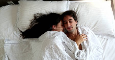 Téléchargez les photos : Couple lying in bed in the morning under blanket - en image libre de droit