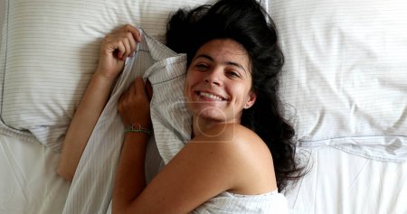 Téléchargez les photos : Funny young woman playing hide and seek peekaboo under blanket in bed - en image libre de droit