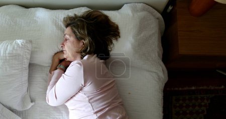 Téléchargez les photos : Tired older woman resting taking afternoon nap - en image libre de droit