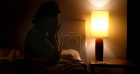 Téléchargez les photos : Woman sitting by the side of bed unable to sleep at night, sleepless tired person rubbing eye - en image libre de droit