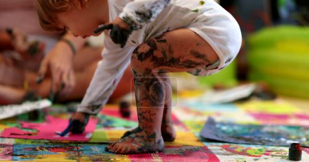Téléchargez les photos : Baby toddler covered in paint, close-up artistic infant legs - en image libre de droit