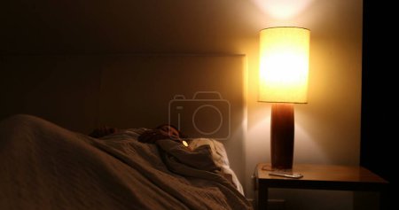 Photo for Sleepless Older woman turns light ON suffering from insomnia - Royalty Free Image