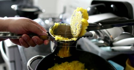 Téléchargez les photos : Close-up hands preparing mandioc food pressing ingredient - en image libre de droit