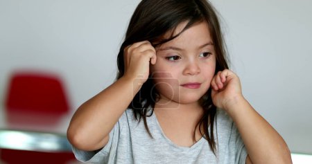 Téléchargez les photos : Tired little girl rubbing eyes with hands - en image libre de droit