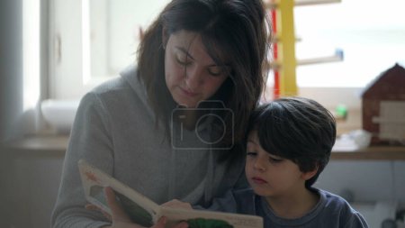 Photo for Mother Reading Story to Little Son, Candid Parenting Moment with Mom and Book, Authentic Bedroom Scene - Royalty Free Image