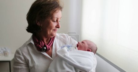 Téléchargez les photos : Grand-mother holding newborn baby in arms - en image libre de droit