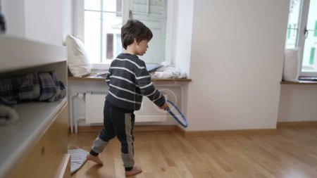 Photo for Little Athlete's Indoor Tennis Session in Vacant Apartment Space, Future Tennis Pro scene of Kid Practicing sport in Empty Apartment Bedroom against wall - Royalty Free Image