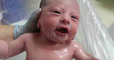 Foto de Newborn baby crying taking bath - Imagen libre de derechos
