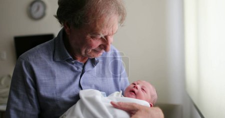 Téléchargez les photos : Nouveau-né bébé étant grand-père à côté de la fenêtre de l'hôpital - en image libre de droit
