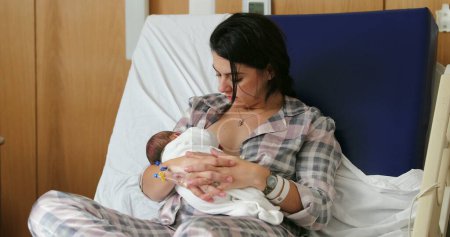 Foto de Mom breastfeeding newborn baby infant at hospital, first day of life - Imagen libre de derechos