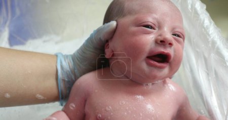 Téléchargez les photos : Nouveau-né pleurant en prenant son bain, vue rapprochée - en image libre de droit