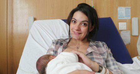 Téléchargez les photos : Mother breastfeeding newborn baby at hospital after birth - en image libre de droit