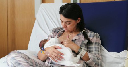 Foto de Mom breastfeeding newborn baby infant at hospital, first day of life - Imagen libre de derechos