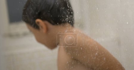 Foto de Tiempo de baño etéreo 1000fps Escena de niño envuelto en gotas de ducha de cámara lenta, atmósfera onírica - Imagen libre de derechos