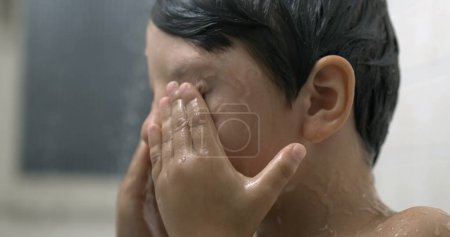 Photo for Child rubbing eyes during bath time in super slow-motion, close-up kid face taking off soap from eye - Royalty Free Image