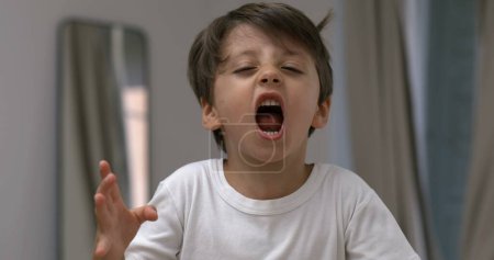 Photo for Angry child yelling and screaming at camera in super slow-motion. Upset male caucasian kid in tantrum mode - Royalty Free Image