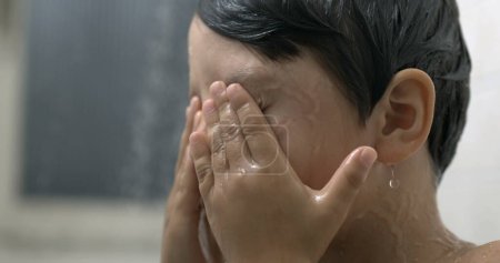 Foto de Niño frotando los ojos durante la hora del baño en super cámara lenta, primer plano cara de niño quitando el jabón de los ojos - Imagen libre de derechos
