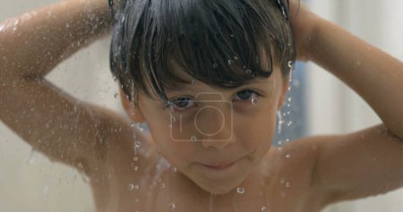 Téléchargez les photos : Clip au ralenti super de la douche pour enfants pendant le bain avec des gouttelettes d'eau qui coulent et éclaboussent - en image libre de droit