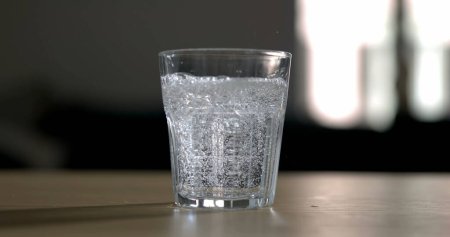 Photo for Pouring sprinkling water into glass cup in super slow-motion 800 fps. Serving hydrating drink - Royalty Free Image