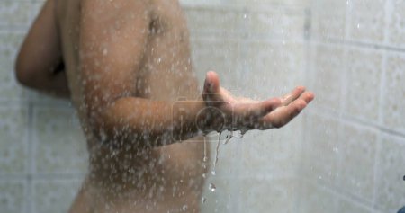 Photo for Droplets flowing in slow-motion 800 fps splashing into child hand while bathing during bath routine, kid washing body in dreamy scene - Royalty Free Image