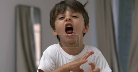 Téléchargez les photos : Enfant en colère criant et criant à la caméra au ralenti super. bouleversé mâle caucasien gosse dans tantrum mode - en image libre de droit