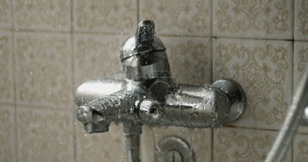 Foto de Gotas cayendo en cámara súper lenta en la válvula de baño que regula la temperatura del agua - Imagen libre de derechos
