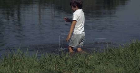 Photo for Child's Joyful Jump in Water , Nature Bond Outdoors, Young Boy Leaping in Lake Creating Splash - Royalty Free Image