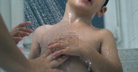 Foto de Madre Lavado Ducha para niños, la mano de los padres bañando la piel del niño con gotitas que fluyen - Imagen libre de derechos