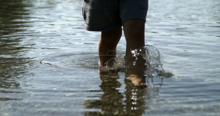 Foto de Niños pies caminando en el agua de la orilla del lago - Imagen libre de derechos
