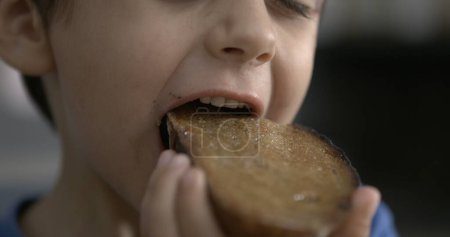 Photo for Speed-Ramp of Little Boy Biting Toast Bread - Royalty Free Image