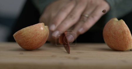 Téléchargez les photos : Couper un fuit de pomme en deux avec un couteau capturé à la caméra - en image libre de droit