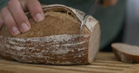 Téléchargez les photos : Tranchage traditionnel du pain, Gros plan sur la sculpture à la main du pain européen - en image libre de droit
