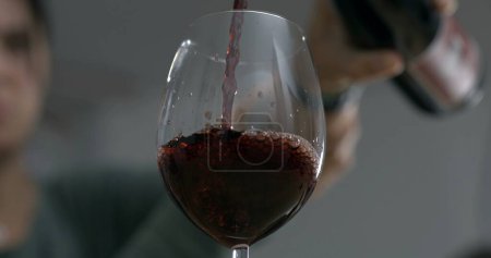 Téléchargez les photos : Valse de vin - Verser dans le verre, élixir élégant - Servir le vin capturé - en image libre de droit