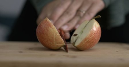Photo for Slicing an apple fuit in half with knife captured in camera - Royalty Free Image