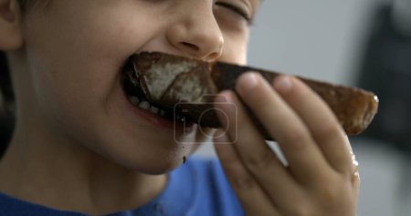 Photo for Child Close-Up mouth - Taking a Bite from Toast . Small boy eating carb food breakfast morning - Royalty Free Image