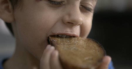 Photo for Speed-Ramp of Little Boy Biting Toast Bread - Royalty Free Image