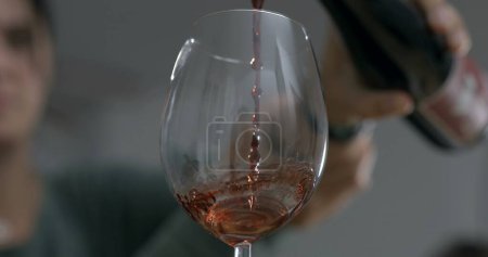 Téléchargez les photos : Servir le vin dans un verre. Verser la célébration des boissons alcoolisées capturées avec la caméra - en image libre de droit