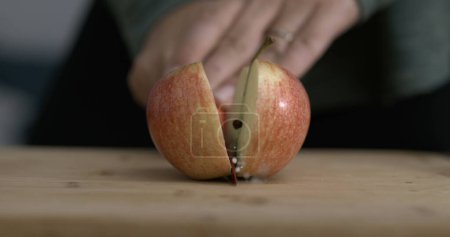 Photo for Slicing an apple fuit in half with knife captured in camera - Royalty Free Image