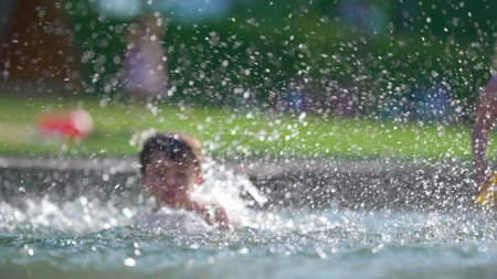 Téléchargez les photos : Enfant à la piscine avec éclaboussures d'eau partout - en image libre de droit