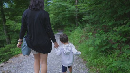 Photo for Mother and Child Walking Hand in Hand in Nature Trail, Enjoying Weekend Hiking Activity. Adventurous family enjoying the great outdoors, journey path road concept - Royalty Free Image