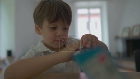 Téléchargez les photos : Petit garçon déchirant avidement cadeau ouvert de boîte de jouet, cadeau déchirant - en image libre de droit
