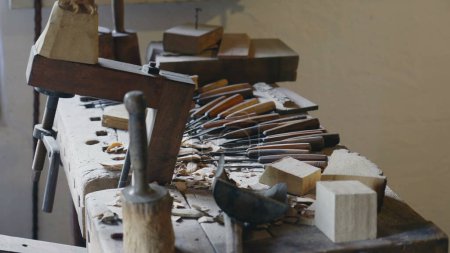 Foto de Primer plano de la mesa de madera atelier con herramientas y equipo artesanal tradicional para la artesanía de objetos en el lugar rústico rural - Imagen libre de derechos