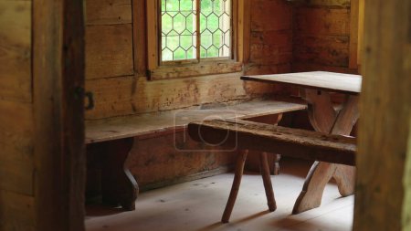 Téléchargez les photos : Intérieur du chalet suisse, plan rapproché de meubles en bois, chaise et table. Simple vie confortable à l'intérieur de la ferme artisanale traditionnelle - en image libre de droit