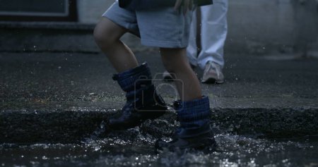 Photo for Kid's Rainboot Steps Sending Water Splashes Soaring, Captured at 800 fps on Sidewalk captured with high-speed camera - Royalty Free Image